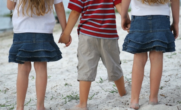 Drei Kinder laufen Hand-in-Hand