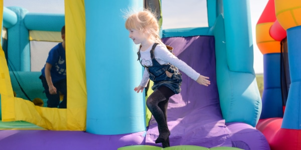Kind spielt auf einer bunten Hüpfburg